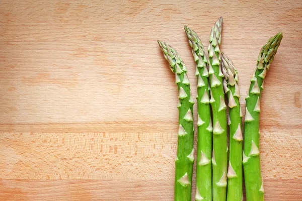 Bunch of green asparagus on wooden desk — Stock Photo, Image