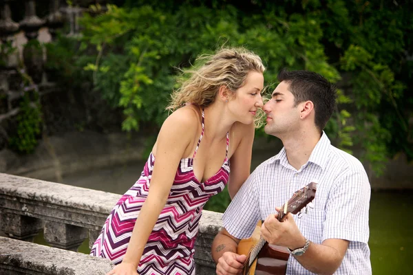 Мужчина играет на гитаре для своей женщины — стоковое фото