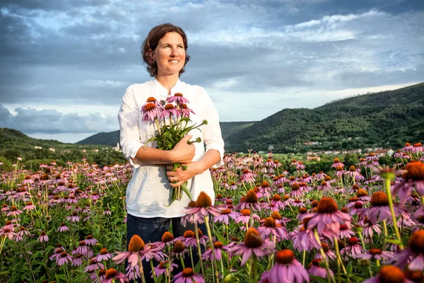 Vrouw in hoornbloem veld — Stockfoto