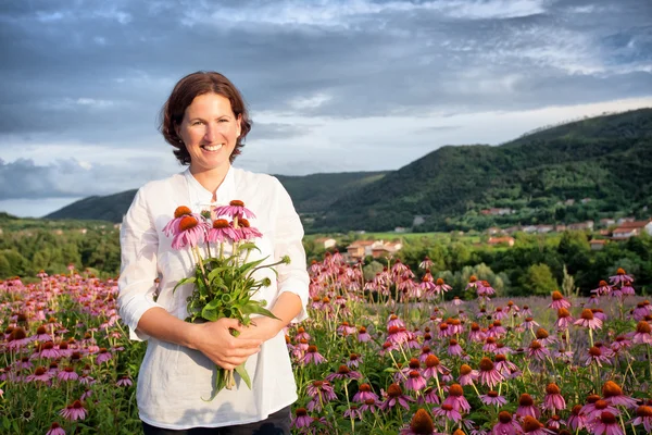 Vrouw in hoornbloem veld — Stockfoto