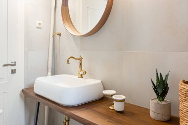 Kiralık dairede banyo teknesi altın rengi musluk ile batıyor.