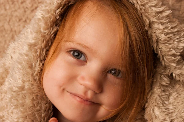 Criança pequena sorrindo com cobertor — Fotografia de Stock