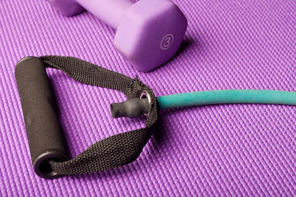 Equipo de ejercicio en una esterilla de yoga púrpura Fotos De Stock Sin Royalties Gratis