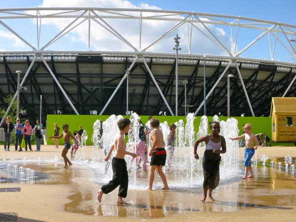 Crianças jogando no parque fora Stratford Olympics stadium, Stratford, East London, Reino Unido Fotografia De Stock