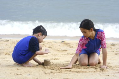 kız ve erkek kardeş bir tropikal plaj kum birlikte zevk.