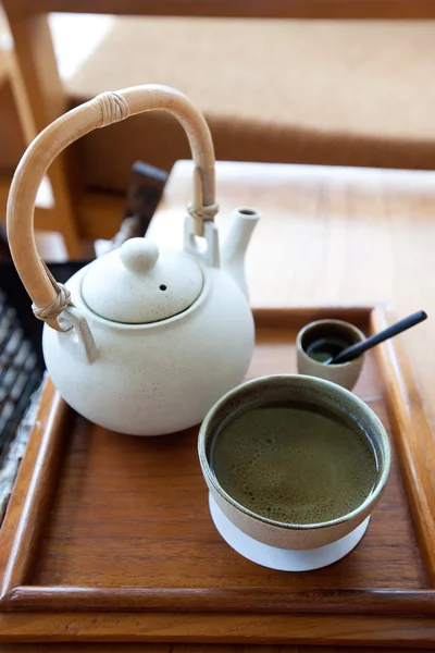 Чашка трав'яного китайського чаю з чайником збоку — стокове фото