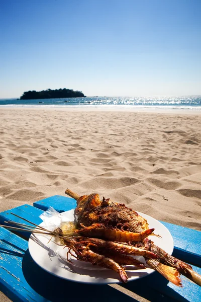 Barbecued fish and prawns by a tropical beach — Stock Photo, Image