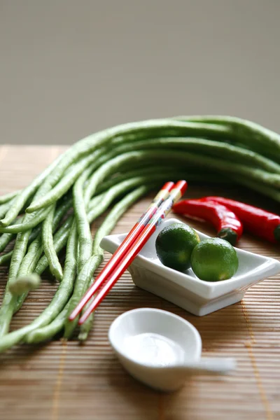 Chinese cooking set with oriental ingredients of long beans, chili and local limes. — Stock Photo, Image