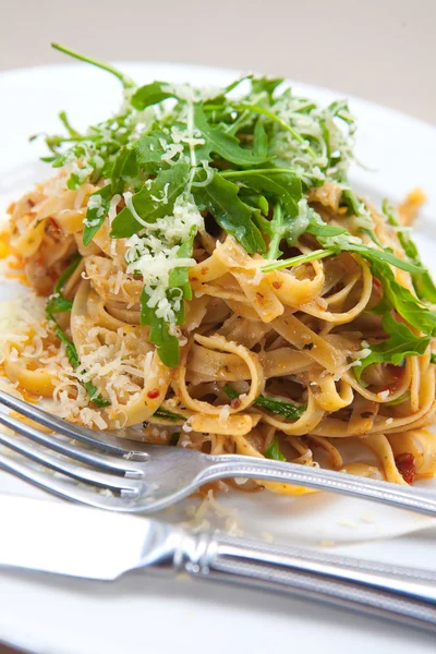 Herkullinen fettucine pasta aurinkokuivattu tomaatti ja raketti lehdet — kuvapankkivalokuva