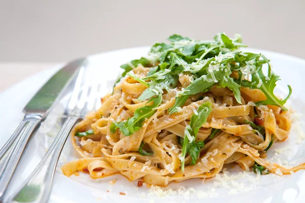 Delicious fettucine pasta with sundried tomato and rocket leaves — Stock Photo, Image