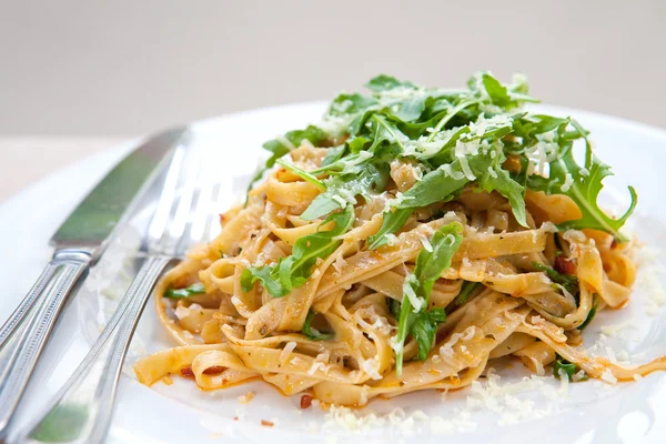 Deliciosa pasta fettucina con tomate seco y hojas de cohete — Foto de Stock