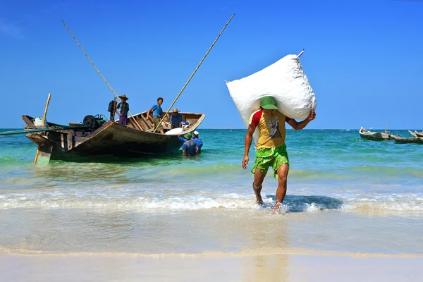 SINMA, MYANMAR JANUARY 31. Workers hauling sacks of dried fish from boats to be sent to markets and shops , Sunday Jan 31, Sin Ma, Myanmar. — Stock Photo, Image