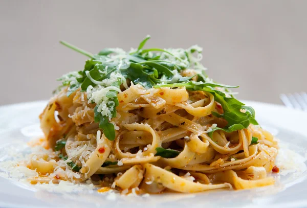 Herkullinen fettucine pasta aurinkokuivattu tomaatti ja raketti lehdet — kuvapankkivalokuva