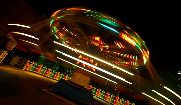 Langsame Verschlusszeit einer Spielplatzfahrt in der Nacht — Stockfoto