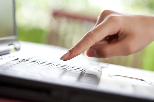 Палец указывает на клавиатуру ноутбука — стоковое фото