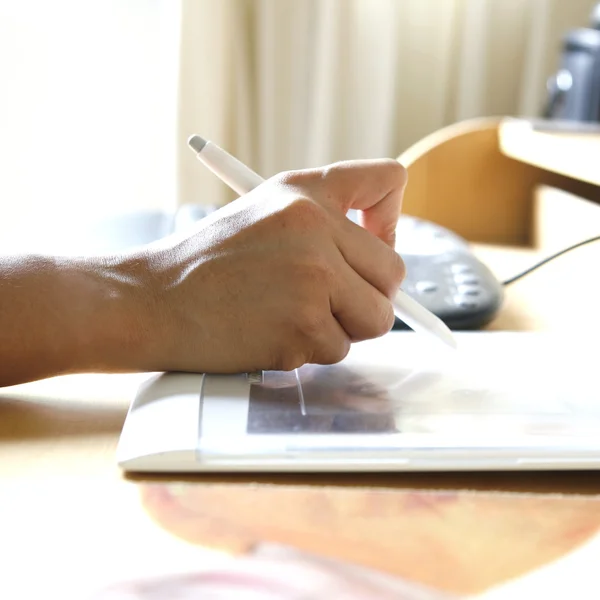 tablet bilgisayara bağlı çalışırken Stylus kalem tutan el.