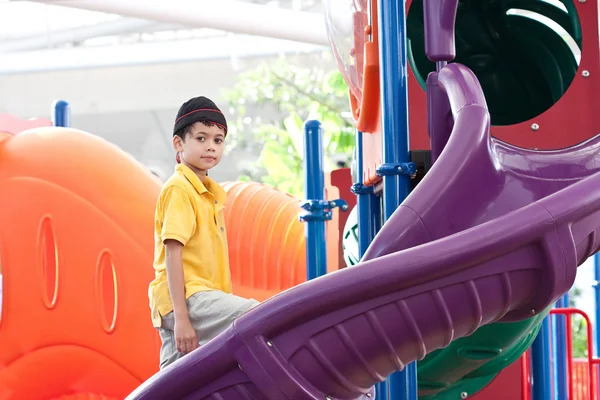 Young boy at colorful outdoor playground — Stock Photo, Image