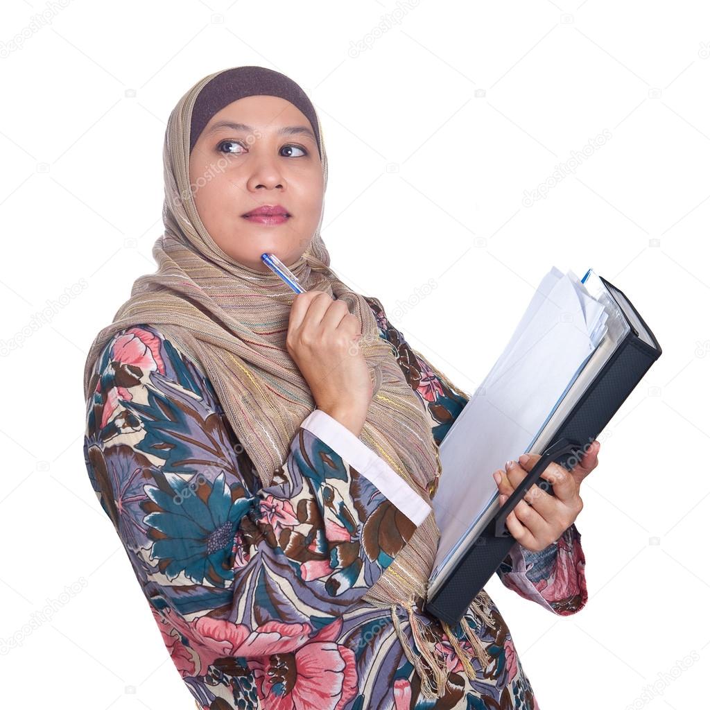 Beautiful mature Muslim woman in thinking pose with files and books in hand