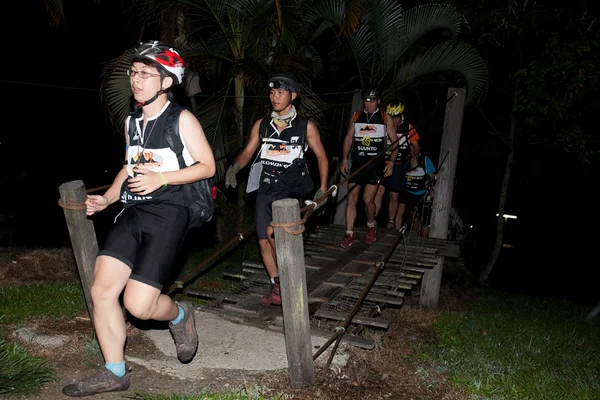 SABAH, MALAYSIA - APRIL 2ND. Participants making their way across the bridge at the early morning 3 am start to the Sabah Adventure Challenge, April 2nd, 2010, Sabah, Malaysia. — Stock Photo, Image