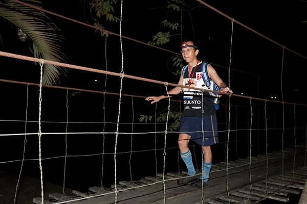 SABAH, MALAYSIA - 2ND APRILE. Un corridore di un team partecipante attraversa un fiume la mattina presto 3 inizio alla Sabah Adventure Challenge, 2 aprile 2010, Sabah, Malesia . — Foto Stock