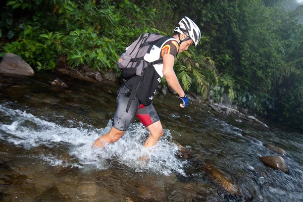 SABAH, MALAISIE - LE 2 AVRIL. Un coureur d'une équipe participante fait son chemin le long d'une rivière dans la course tôt le matin pour le Sabah Adventure Challenge, 2 avril 2010, Sabah, Malaisie . — Photo