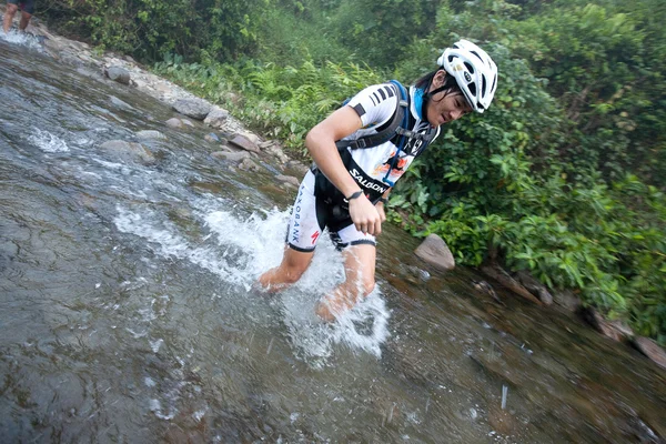 SABAH, MALAYSIA - APRIL 2ND. A racer from a participating team makes his way along a river in the early morning race for the Sabah Adventure Challenge, April 2nd, 2010, Sabah, Malaysia. — Stock Photo, Image