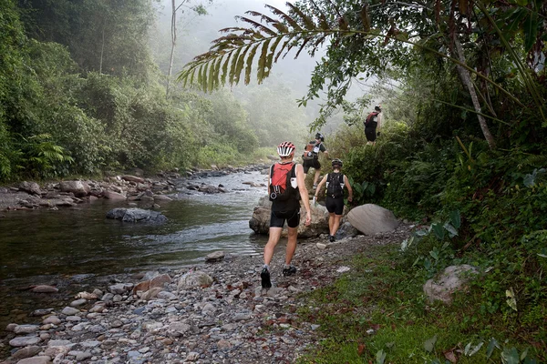 SABAH, MALAISIE - LE 2 AVRIL. Une équipe de course se fraye un chemin le long d'une rivière en début de matinée pour le Sabah Adventure Challenge, 2 avril 2010, Sabah, Malaisie . — Photo