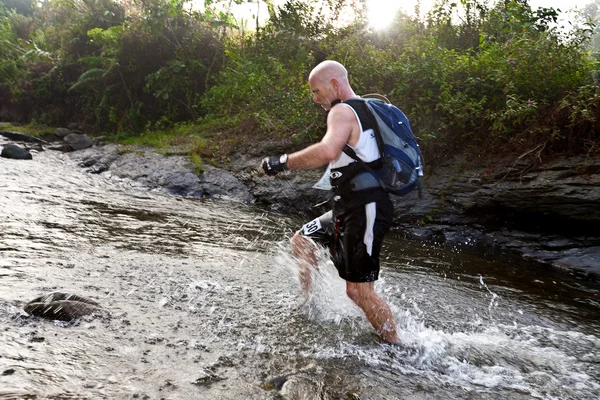 SABAH, MALAISIE - LE 2 AVRIL. Un coureur d'une équipe participante fait son chemin le long d'une rivière dans la course tôt le matin pour le Sabah Adventure Challenge, 2 avril 2010, Sabah, Malaisie . — Photo