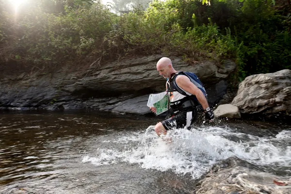 SABAH, MALAISIE - LE 2 AVRIL. Un coureur d'une équipe participante fait son chemin le long d'une rivière dans la course tôt le matin pour le Sabah Adventure Challenge, 2 avril 2010, Sabah, Malaisie . — Photo