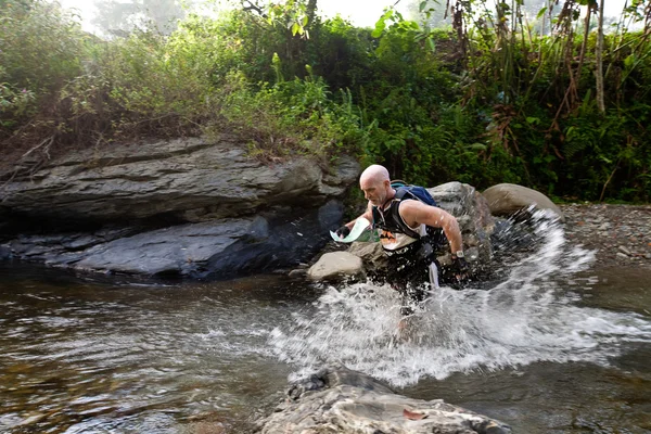 SABAH, MALAISIE - LE 2 AVRIL. Un coureur d'une équipe participante fait son chemin le long d'une rivière dans la course tôt le matin pour le Sabah Adventure Challenge, 2 avril 2010, Sabah, Malaisie . — Photo