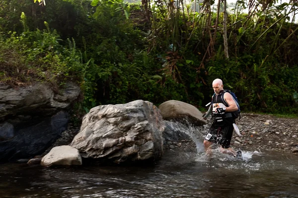 SABAH, MALAISIE - LE 2 AVRIL. Un coureur d'une équipe participante fait son chemin le long d'une rivière dans la course tôt le matin pour le Sabah Adventure Challenge, 2 avril 2010, Sabah, Malaisie . — Photo