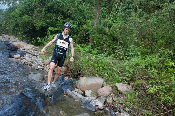 SABAH, MALASIA - 2 DE ABRIL. Un corredor de un equipo participante hace su camino a lo largo de un río en la carrera de la madrugada para el Sabah Adventure Challenge, 2 de abril de 2010, Sabah, Malasia . —  Fotos de Stock