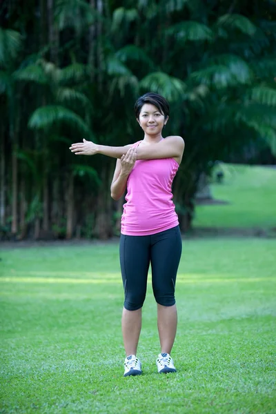 Fitness vrouw doen rekoefeningen buiten in het park — Stockfoto