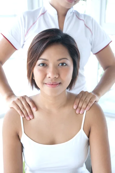 Young Asian woman receiving a shoulder massage by therapist — Stock Photo, Image