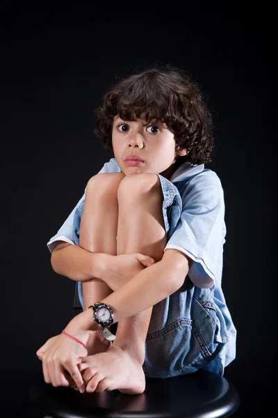 Молодой мальчик обнимает себя в положении самозащиты . — стоковое фото