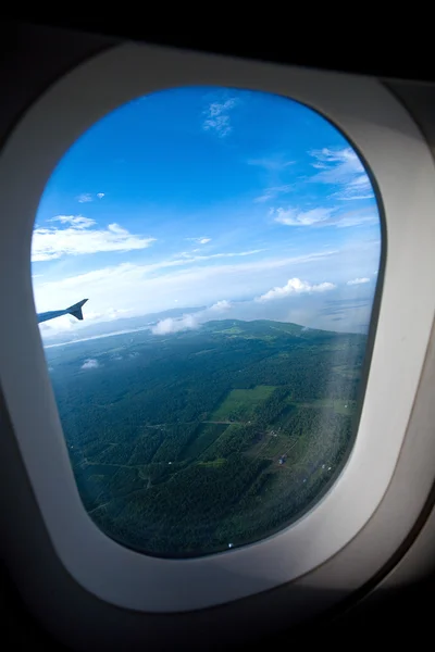 Vista de la masa de tierra forestal vista a través de la ventana de un avión — Foto de Stock