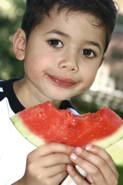 Niño disfrutando de una jugosa sandía roja — Foto de Stock