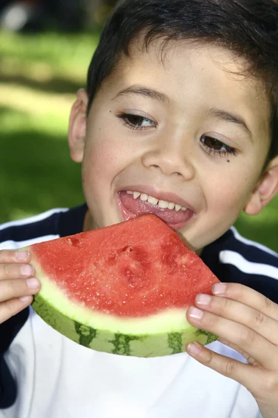 Niño disfrutando de una jugosa sandía roja — Foto de Stock