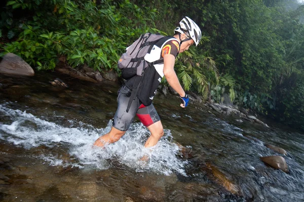 Une équipe de course faisant leur chemin le long d'une rivière dans la course tôt le matin — Photo