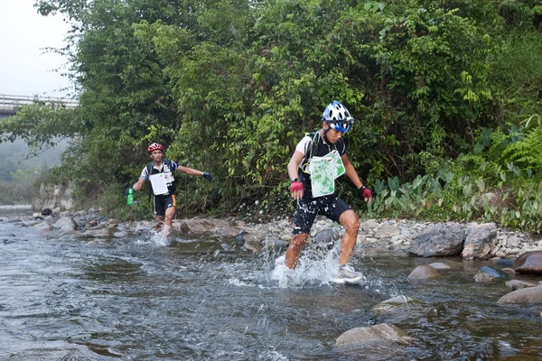 Une équipe de course faisant leur chemin le long d'une rivière dans la course tôt le matin — Photo