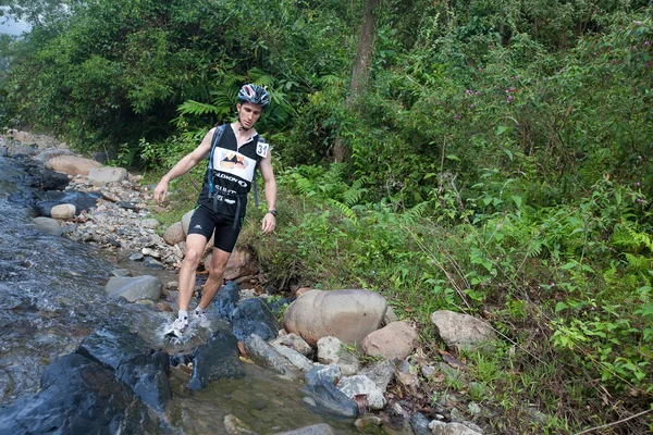 A racer from a participating team makes his way along a river — Stock Photo, Image