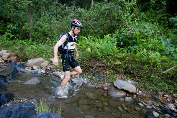 A racer from a participating team makes his way along a river — Stock Photo, Image