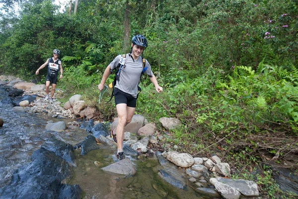 Závodník z zúčastněný tým dělá jeho cestu podél řeky — Stock fotografie