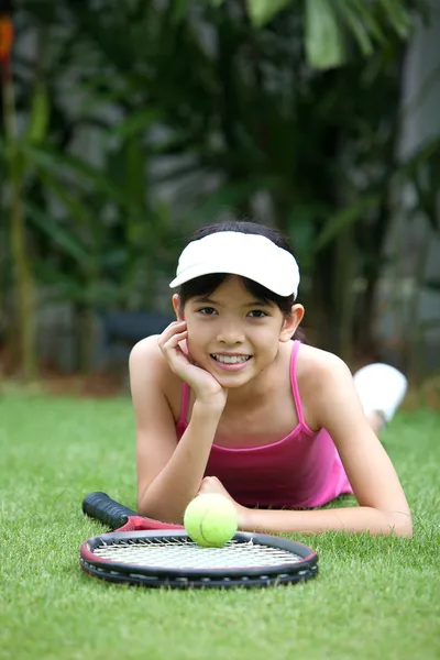 Giovane ragazza con una racchetta da tennis e una palla da tennis in giardino . — Foto Stock
