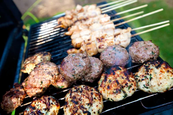 Burgers et brochettes de poulet sur un barbecue chaud en plein air . Photos De Stock Libres De Droits