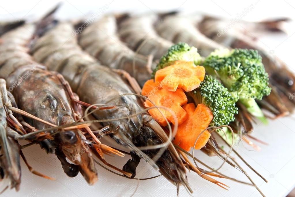Fresh tiger prawn on white plate with vegetable garnishing