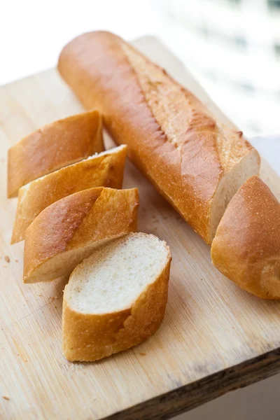 Frisch gebackene französische Bagguette auf Holzbrett — Stockfoto