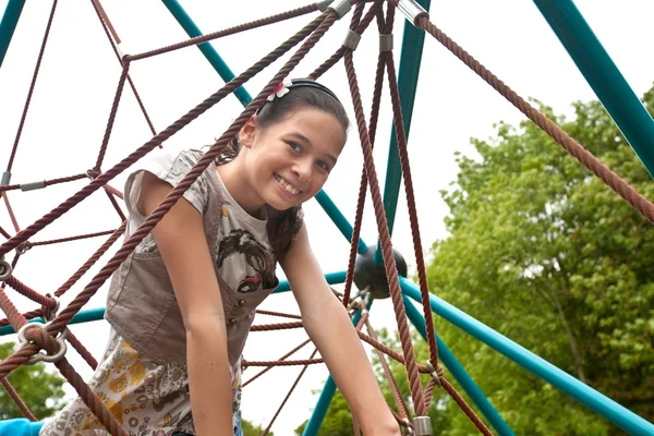 Pretty teenager on a climbing frame in a park — Stock Photo, Image