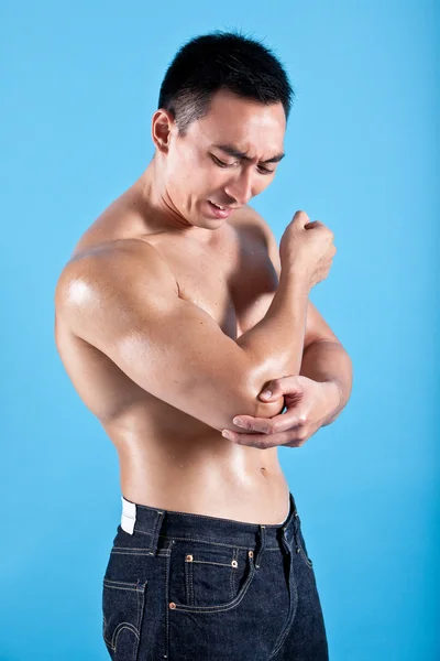 Young fit man suffering from painful elbow injury — Stock Photo, Image