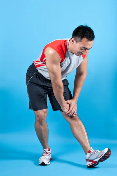 Joven hombre en forma haciendo estiramiento isquiotibial —  Fotos de Stock